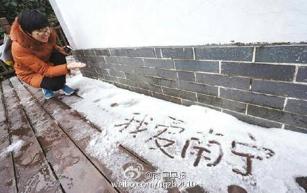 攝影愛(ài)好者爬上高處拍攝遮陽(yáng)傘上的積雪
