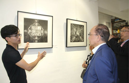 方偉向參展者介紹作品，該幅畫作曾在2015年于北京鳥巢展出（攝影：吳玉潔）