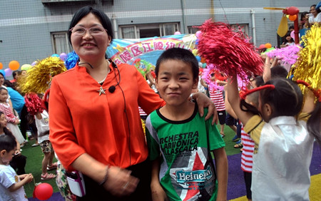 江陵幼兒園院長譚英同貧困生陳繼飛合影.JPG