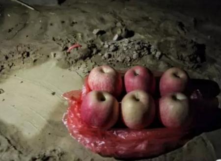 失去孩子的父母在被洪水沖毀的屋外放著貢品.jpg