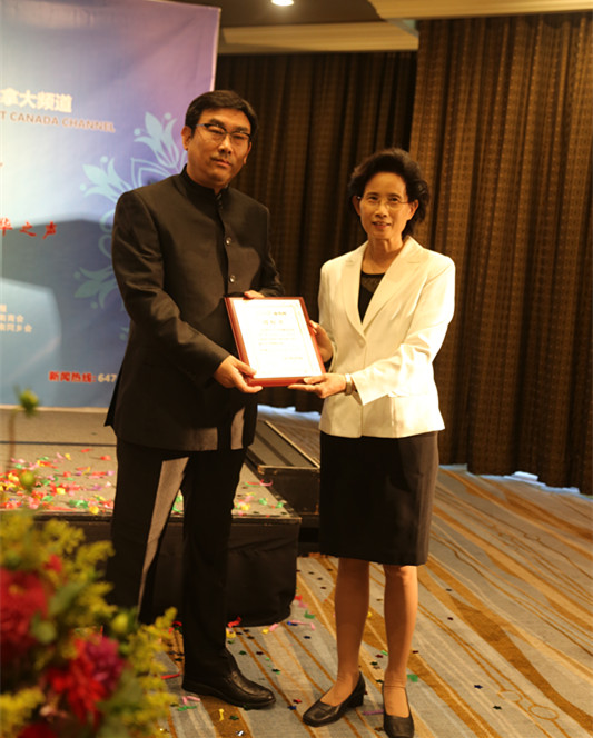 人民日報海外版副總編輯劉玉琴為加拿大頻道執(zhí)行總編、中華傳媒集團(tuán)董事長常建國授牌。（呂文寶 攝）.jpg