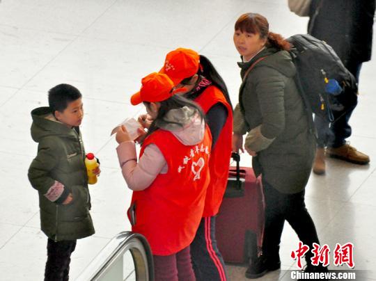 鐵路青年志愿者為攜帶兒童出行的旅客提供咨詢解答。吳正琪攝