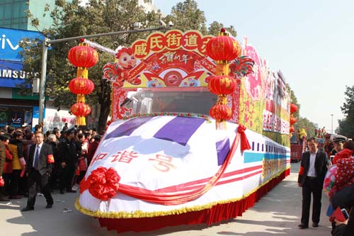 “和諧號(hào)”政策宣傳車在人群的簇?fù)硐埋傁蚯胺?王波 攝.JPG