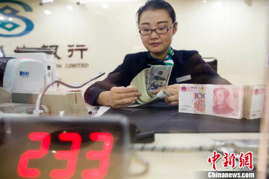 山西太原，銀行工作人員正在清點(diǎn)貨幣。張?jiān)?攝