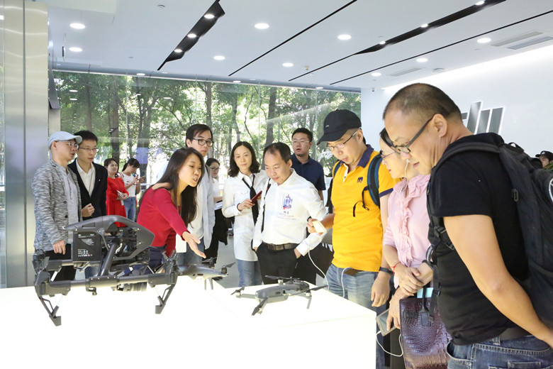 媒體采訪團認真聽取工作人員介紹大疆無人機產(chǎn)品.jpg