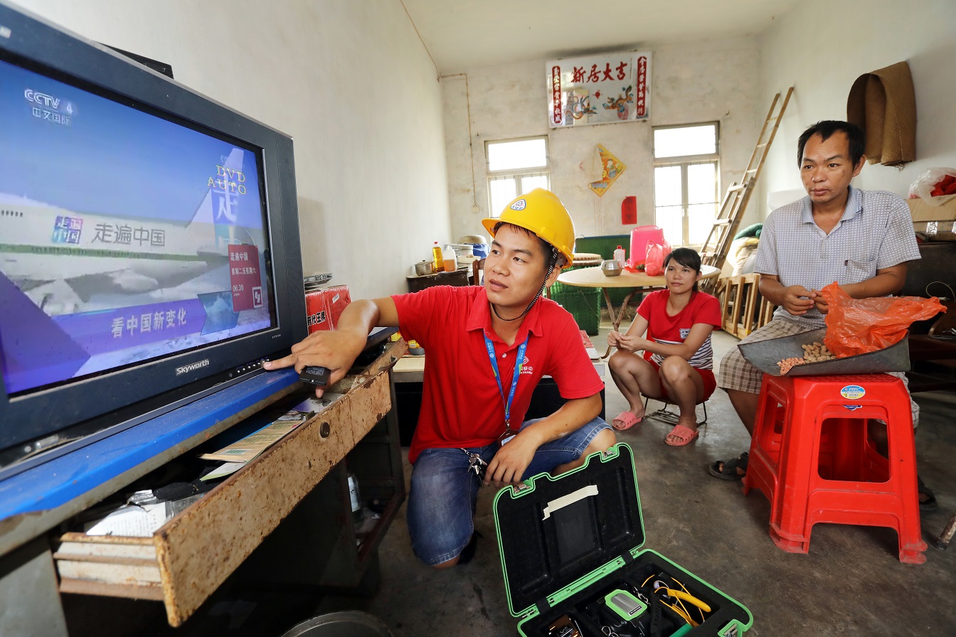隨著電信普遍服務(wù)工作推進(jìn)，湛江市麻章區(qū)水塘村也實(shí)現(xiàn)了移動光纖覆蓋。圖為廣東移動裝維人員為村民安裝寬帶，調(diào)試電視.jpg