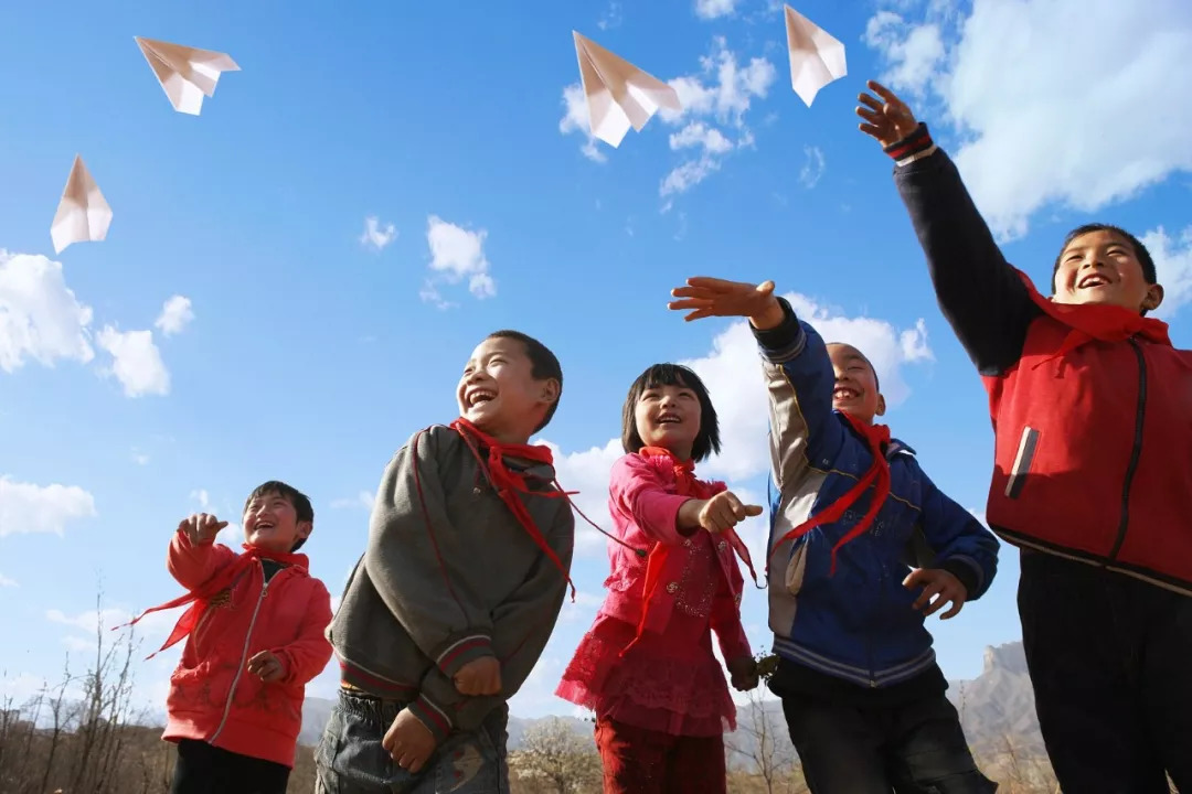幾個來自鄉(xiāng)村小學的孩子放飛紙飛機。/ 視覺中國