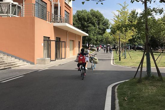 學(xué)生用共享單車將快遞拿回寢室。