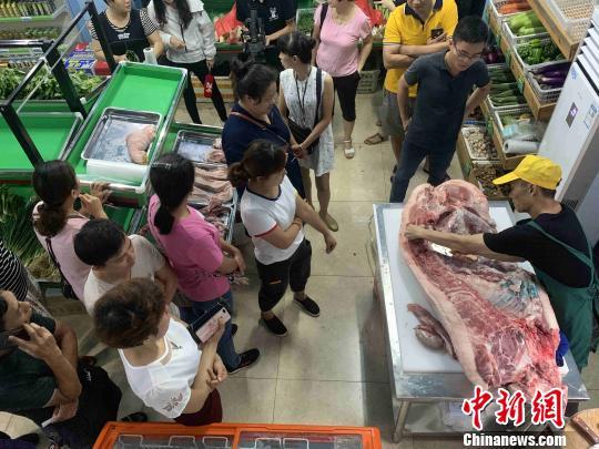 資料圖：市民在?？谑胁嘶@子銷售點(diǎn)購買“放心豬肉”。王子謙 攝