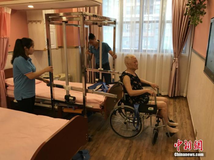 資料圖：重慶一養(yǎng)老服務(wù)所自主設(shè)計的一款專為失能老人服務(wù)的“移動機”正式投用。 鐘欣 攝