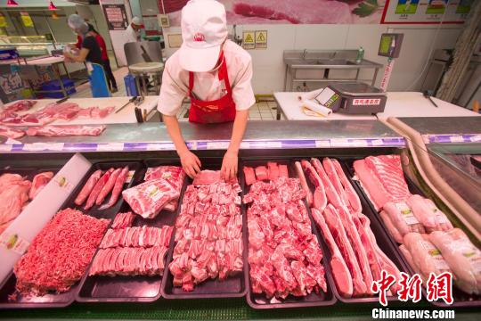 資料圖：山西太原，超市員工在整理豬肉。張?jiān)?攝