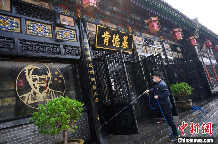 工作人員在古城里清潔店鋪門面。韋亮 攝