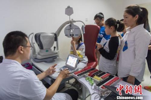 資料圖：中小學(xué)生在家長(zhǎng)的陪同下檢查視力。韋亮 攝