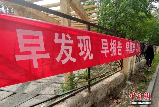 6月16日，北京花鄉(xiāng)地區(qū)一街道邊，工作人員正在懸掛防疫宣傳橫幅。a target='_blank' href='http://www.chinanews.com/'中新社/a記者 張宇 攝