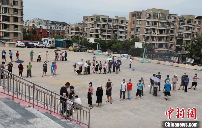 圖為市民在沙河口區(qū)中學(xué)生勞動(dòng)技術(shù)中心檢測(cè)點(diǎn)排隊(duì)接受檢測(cè)。楊毅 攝