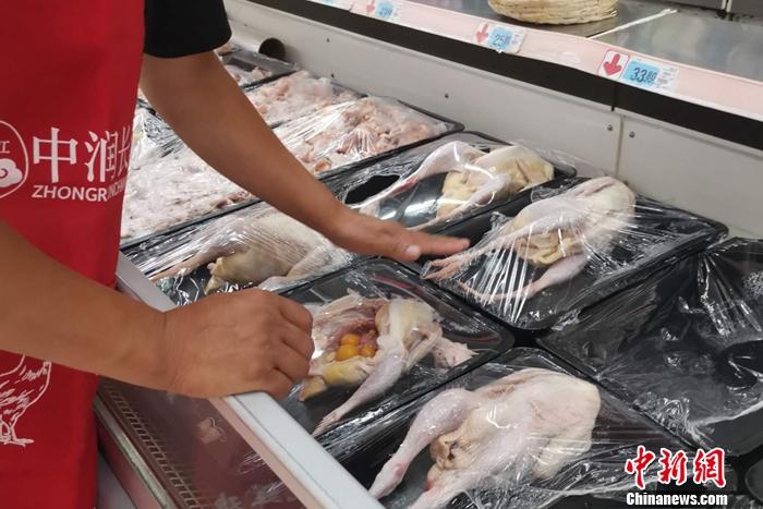 圖為超市工作人員在介紹整雞價格。 謝藝觀 攝