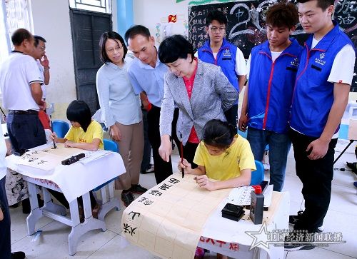 李紅梅一行觀摩亞欠村小學(xué)生練習(xí)書法.jpg