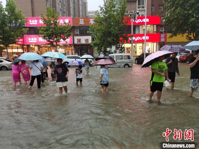 資料圖：鄭州7·20特大暴雨后，市民在街道上趟水而過。王登峰 攝