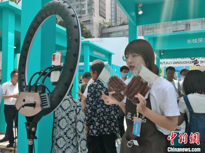 圖為“巫姑臘味”展區(qū)工作人員正在直播。袁子寒 攝